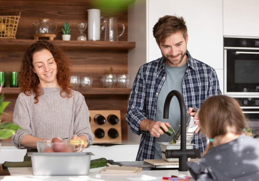 Busy family preparing dinner at sink